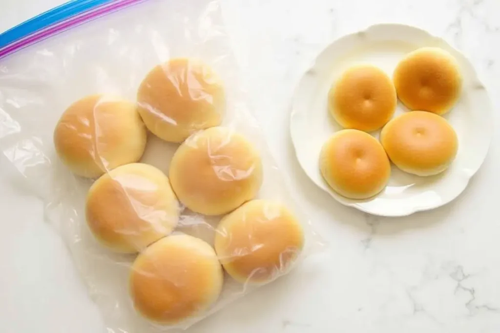 Egg white burger buns stored in a resealable plastic bag with some on a plate.