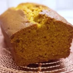 Close-up of moist vanilla pudding pumpkin bread loaf, freshly baked and cooling on a rack
